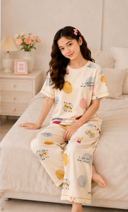 Light Beige Giraffe Girls Night Suit - seated on bed