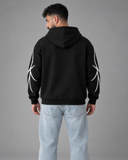 Rear model view of black Branch Print fleece hoodie showing plain black back and sleeve graphics